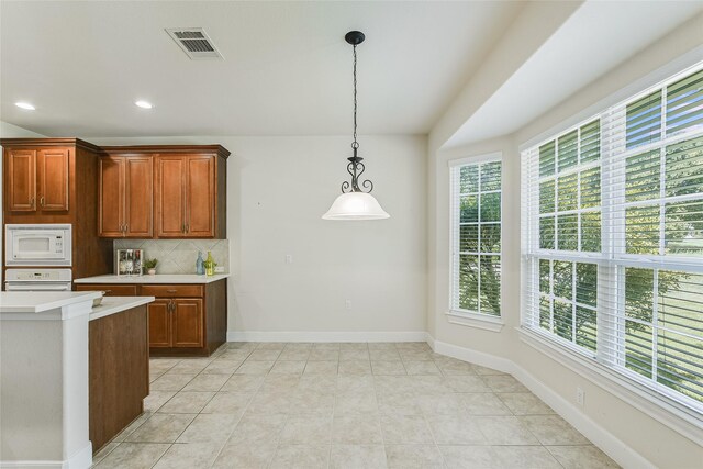 kitchen with decorative backsplash, light tile patterned flooring, decorative light fixtures, and white appliances