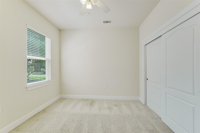 unfurnished bedroom with carpet flooring, a closet, and ceiling fan