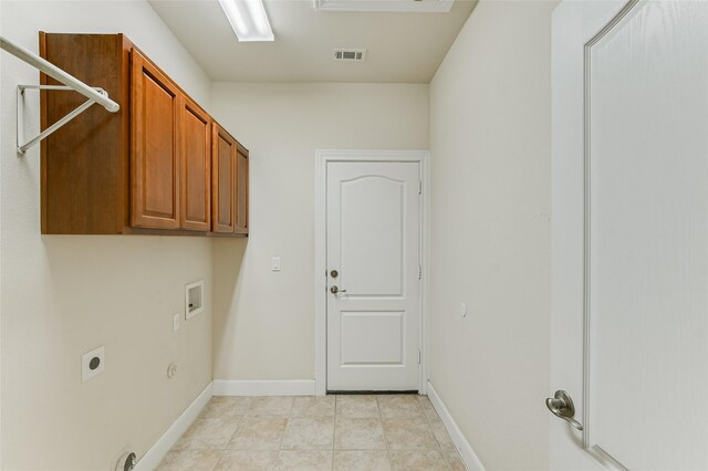 washroom with cabinets, light tile patterned floors, electric dryer hookup, gas dryer hookup, and washer hookup