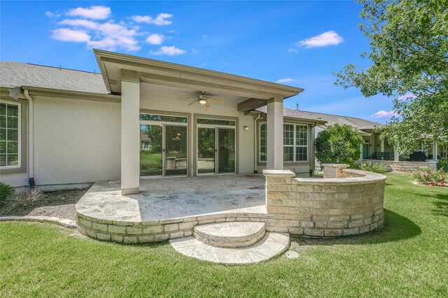 back of property with a patio, ceiling fan, and a yard