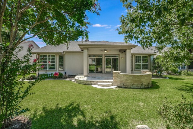 rear view of property featuring ceiling fan, a yard, and a patio area