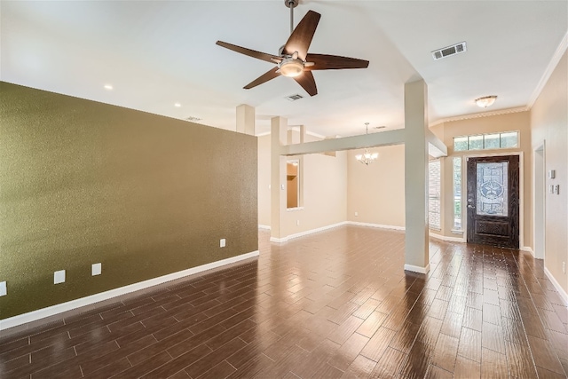 empty room with ceiling fan with notable chandelier, vaulted ceiling, and crown molding