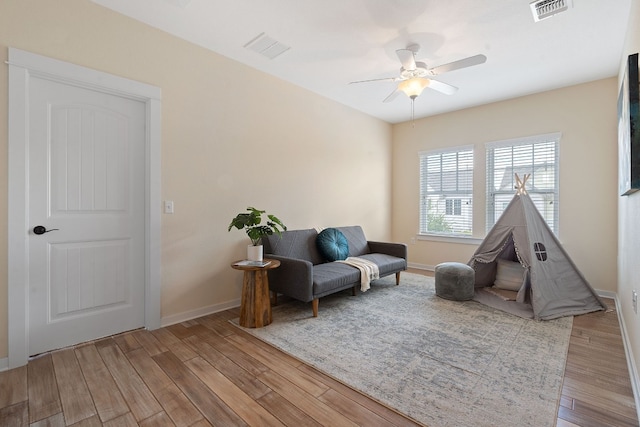 living area featuring light wood-type flooring and ceiling fan