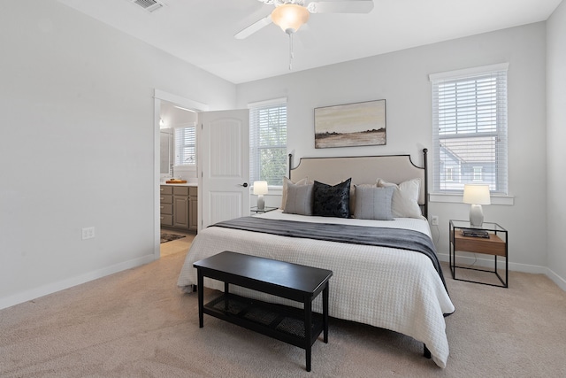 carpeted bedroom with ceiling fan and ensuite bath