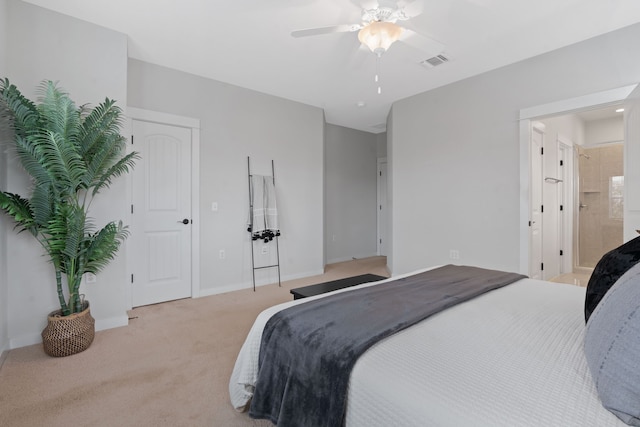 carpeted bedroom with ceiling fan and ensuite bath