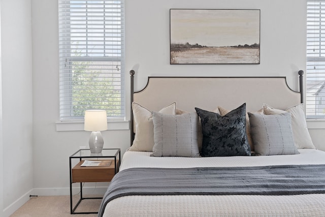 carpeted bedroom featuring multiple windows