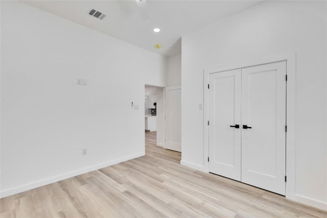 unfurnished bedroom with ceiling fan, a closet, and light wood-type flooring