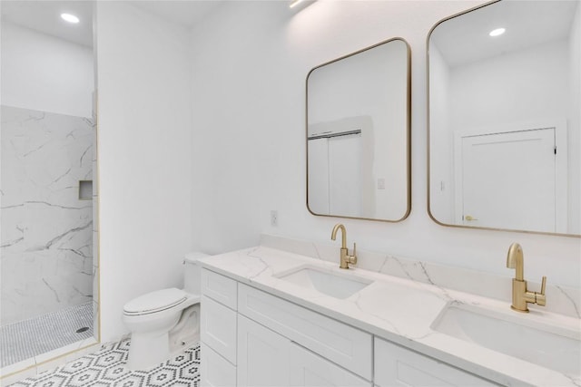 bathroom featuring vanity, toilet, and tiled shower