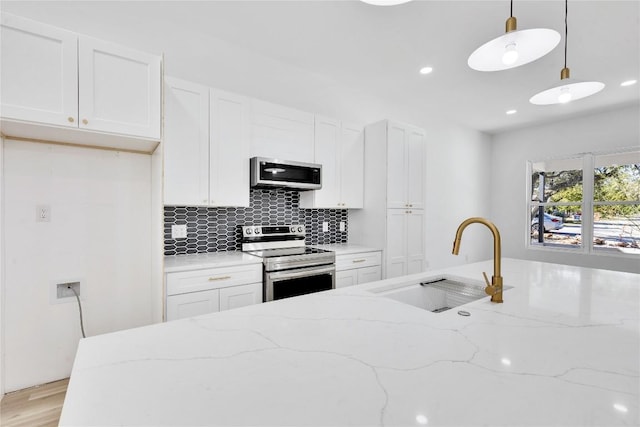 kitchen featuring white cabinetry, sink, stainless steel appliances, hanging light fixtures, and light stone counters