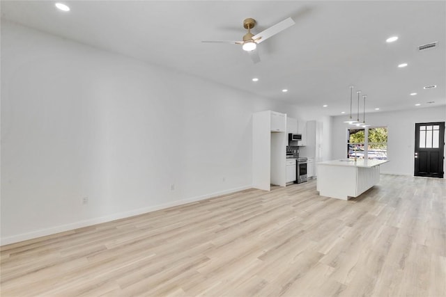 kitchen with pendant lighting, a kitchen island with sink, light hardwood / wood-style floors, white cabinetry, and stainless steel appliances