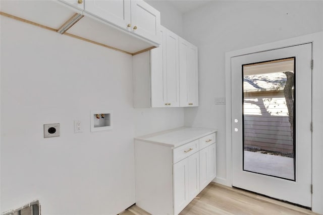 washroom with cabinets, hookup for a washing machine, light hardwood / wood-style flooring, and electric dryer hookup