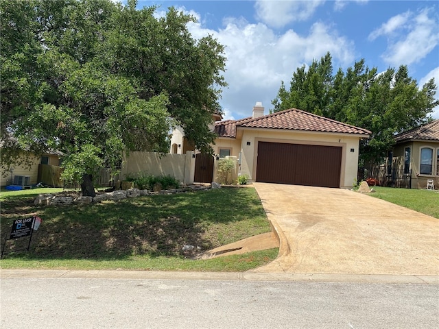 mediterranean / spanish home with a garage and a front lawn