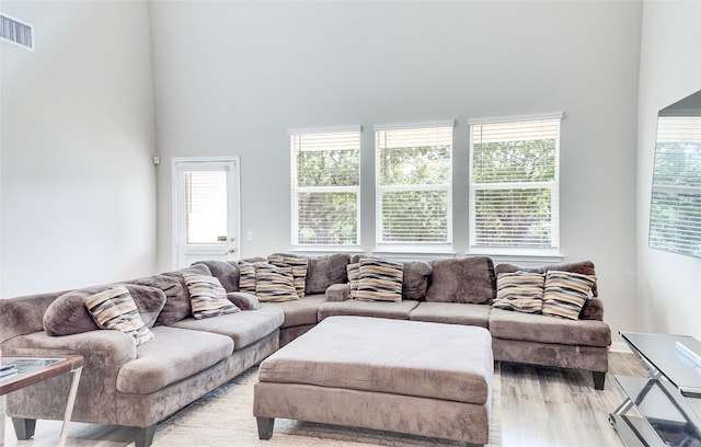 living room featuring light hardwood / wood-style flooring and a high ceiling