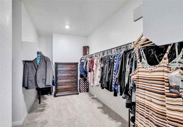 walk in closet with light colored carpet