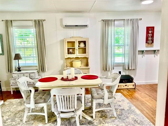 dining area with a wall mounted AC, a healthy amount of sunlight, and wood-type flooring