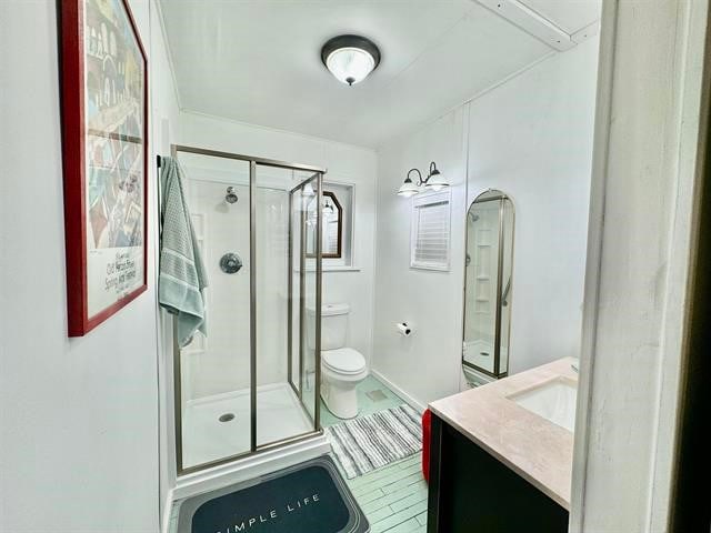 bathroom with toilet, a shower with door, and vanity