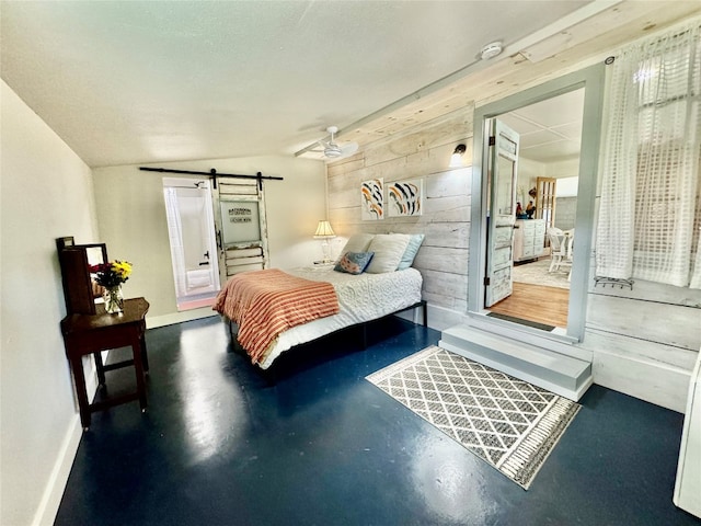 bedroom featuring vaulted ceiling, concrete flooring, and a barn door