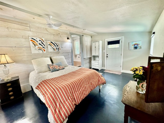 bedroom with a textured ceiling, ensuite bath, ceiling fan, lofted ceiling, and concrete flooring