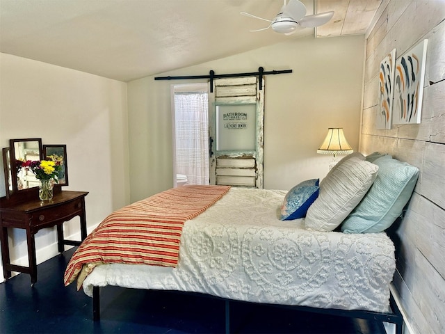 bedroom featuring lofted ceiling, a barn door, and ceiling fan