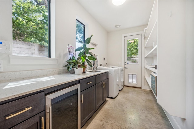 washroom featuring cabinets, wine cooler, independent washer and dryer, and sink