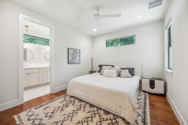 bedroom featuring ceiling fan, ensuite bath, and dark hardwood / wood-style flooring