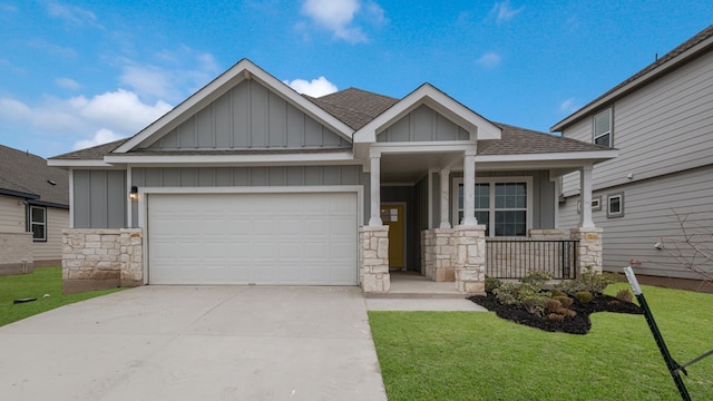 craftsman-style home with a garage, stone siding, board and batten siding, and a front yard