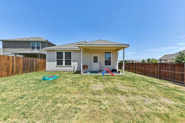 rear view of property with a lawn and a patio