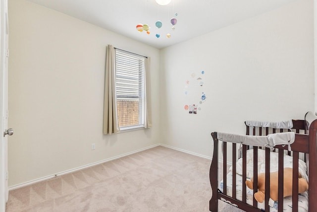 bedroom with light colored carpet and a nursery area