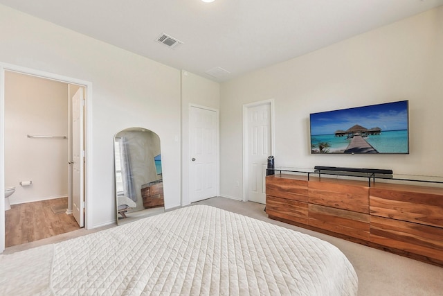 carpeted bedroom featuring ensuite bath