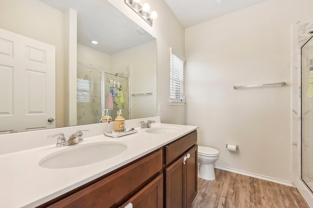 bathroom featuring toilet, an enclosed shower, vanity, and wood-type flooring