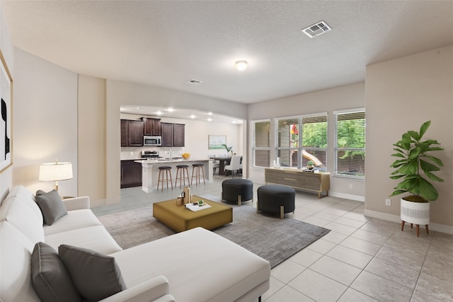 living room with a textured ceiling and light tile patterned floors