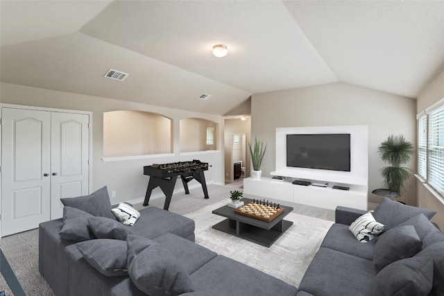 carpeted living room featuring lofted ceiling