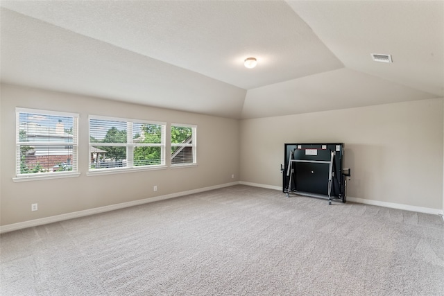 bonus room with light carpet and lofted ceiling