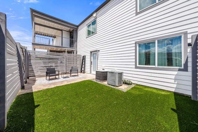 back of property with cooling unit, a patio area, and a yard