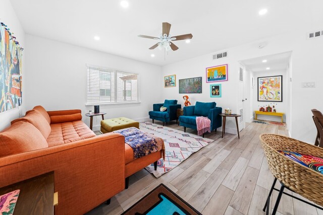 living room with light wood-type flooring and ceiling fan