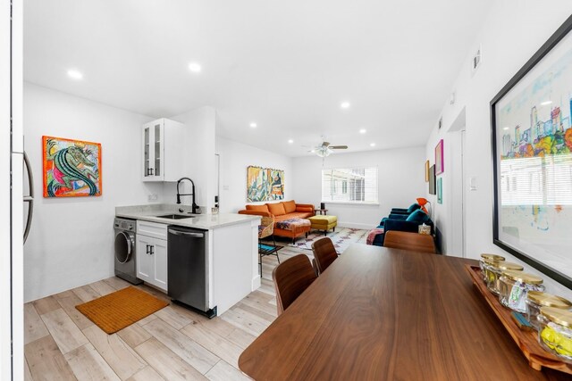 kitchen featuring washer / dryer, dishwasher, white cabinets, sink, and ceiling fan