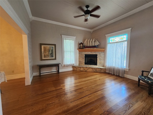 unfurnished living room featuring hardwood / wood-style flooring, plenty of natural light, ceiling fan, and a stone fireplace