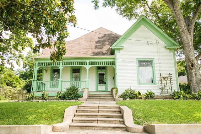 view of front of property with covered porch and a front yard