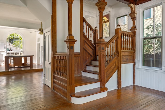 stairs featuring wood-type flooring and ceiling fan