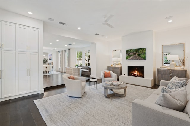 living room featuring dark wood-type flooring and ceiling fan