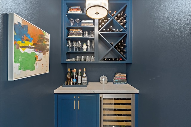 bar with beverage cooler and blue cabinets