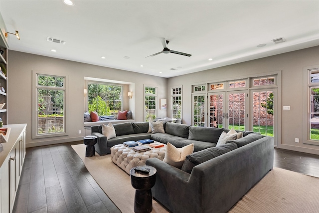 living room featuring dark wood-type flooring and ceiling fan