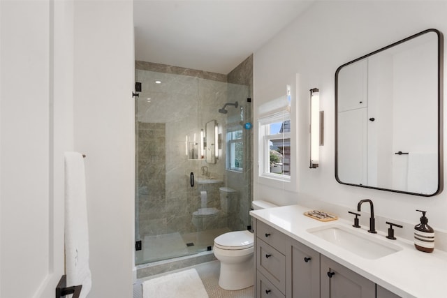 bathroom with a shower with shower door, vanity, and toilet