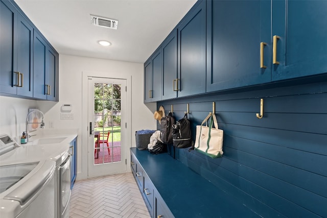 mudroom with washer and dryer and sink