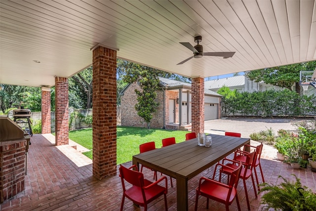 view of patio / terrace featuring a garage, an outbuilding, and ceiling fan