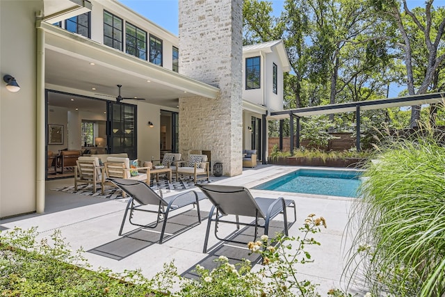 view of swimming pool with ceiling fan, a patio, and outdoor lounge area