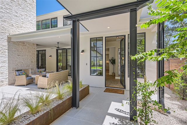 view of exterior entry featuring ceiling fan, an outdoor hangout area, and a patio area