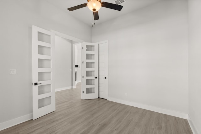 empty room featuring ceiling fan, light hardwood / wood-style flooring, and french doors