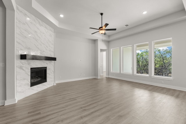 unfurnished living room with a fireplace, wood-type flooring, and ceiling fan