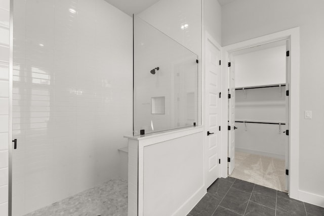 bathroom with tiled shower and tile patterned floors